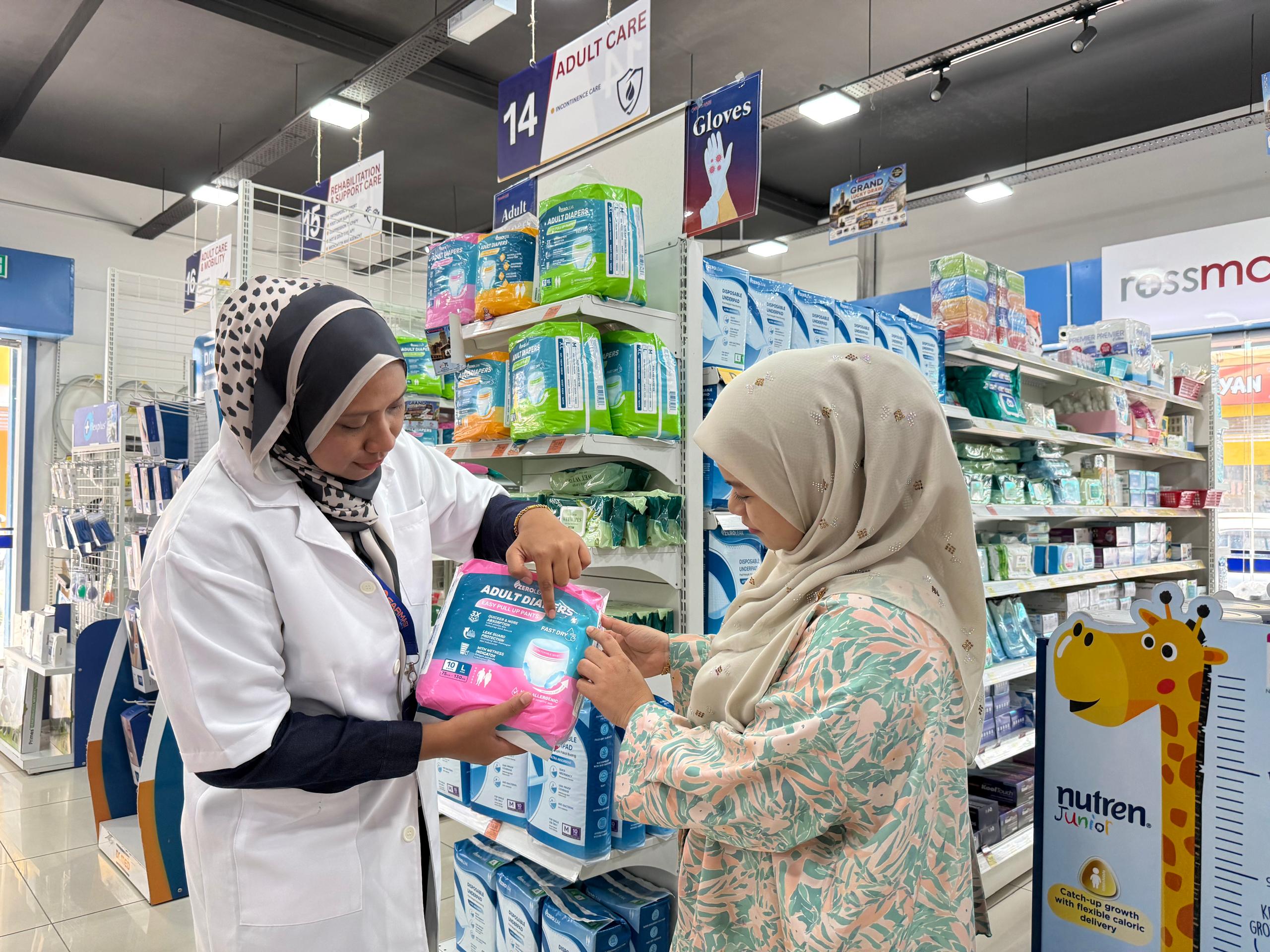 A Farmasi Lautan pharmacist helping a customer choose a product